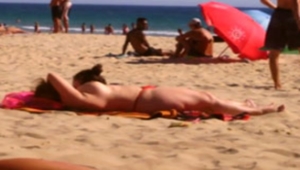 Coroa fazendo topless na praia exibindo peitos grandes